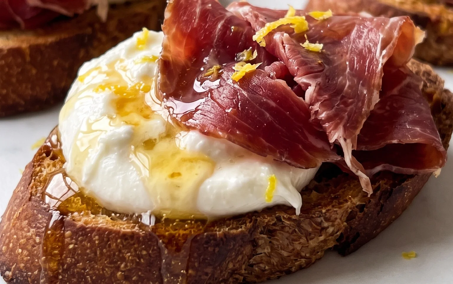 Beef Prosciutto Crostini with Burrata and Lemon Honey Drizzle